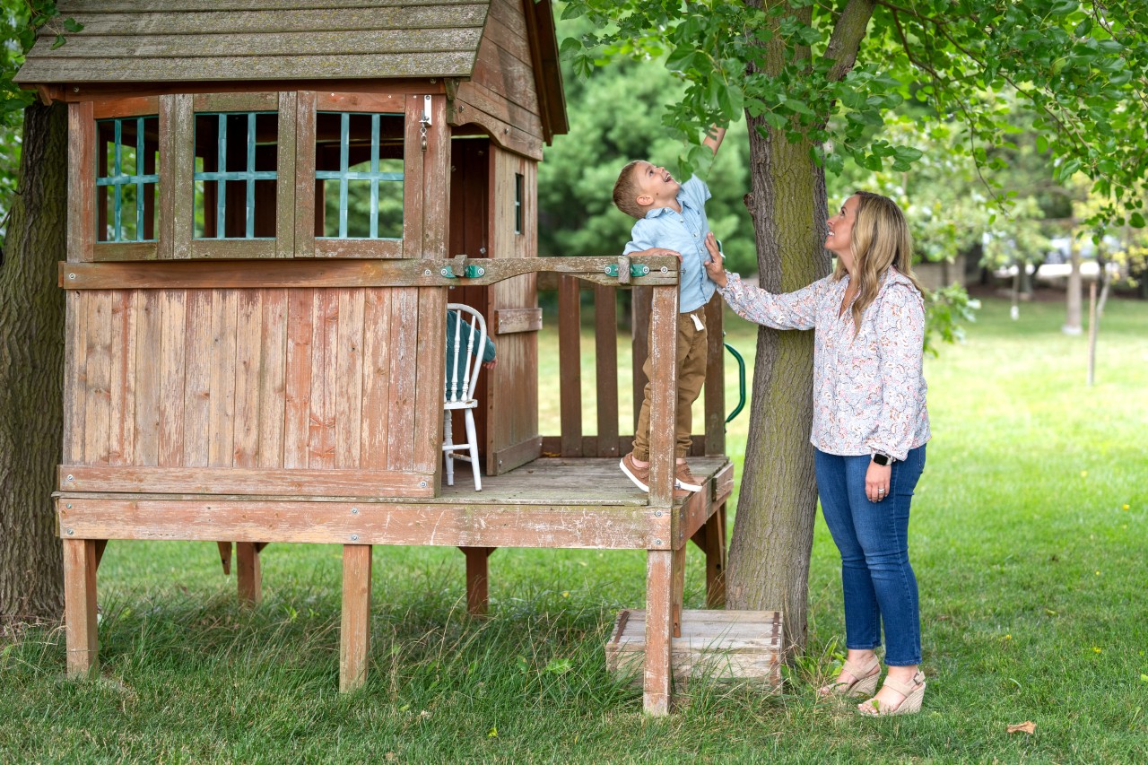 Mother and son play on treehouse.
