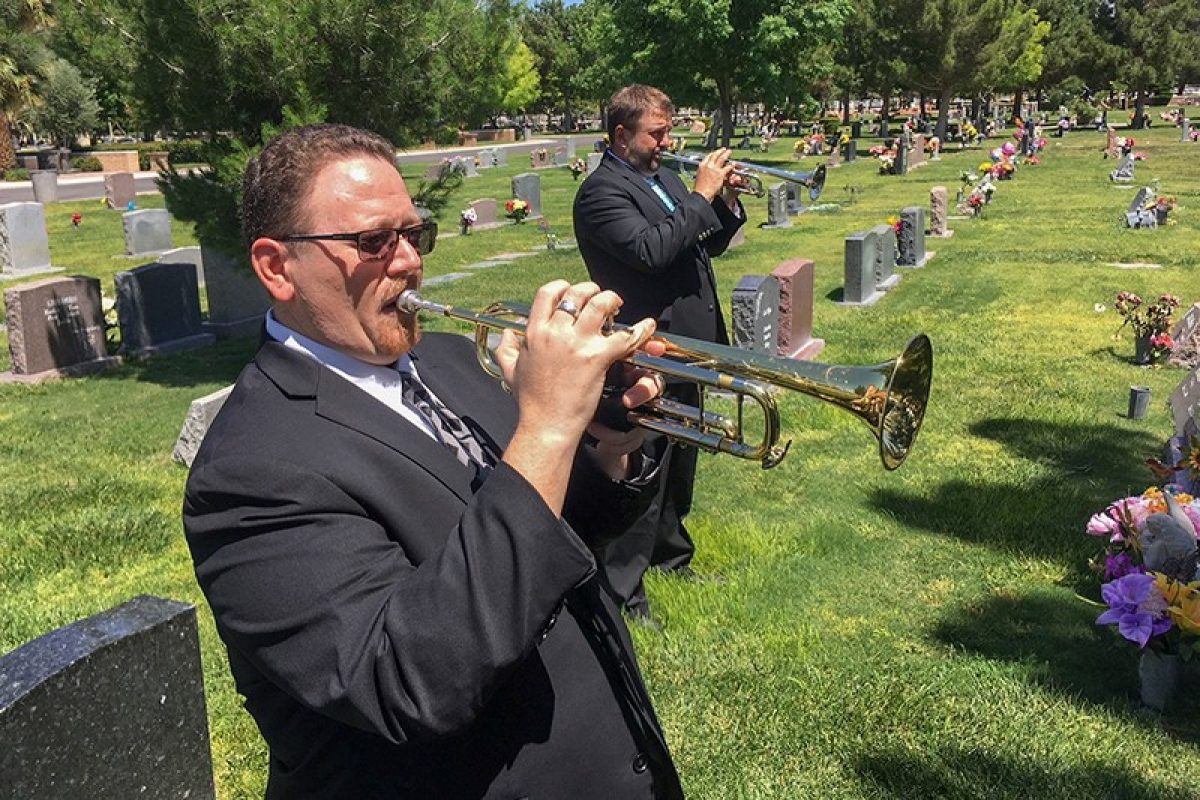 Men in suits at funeral playing trumpets