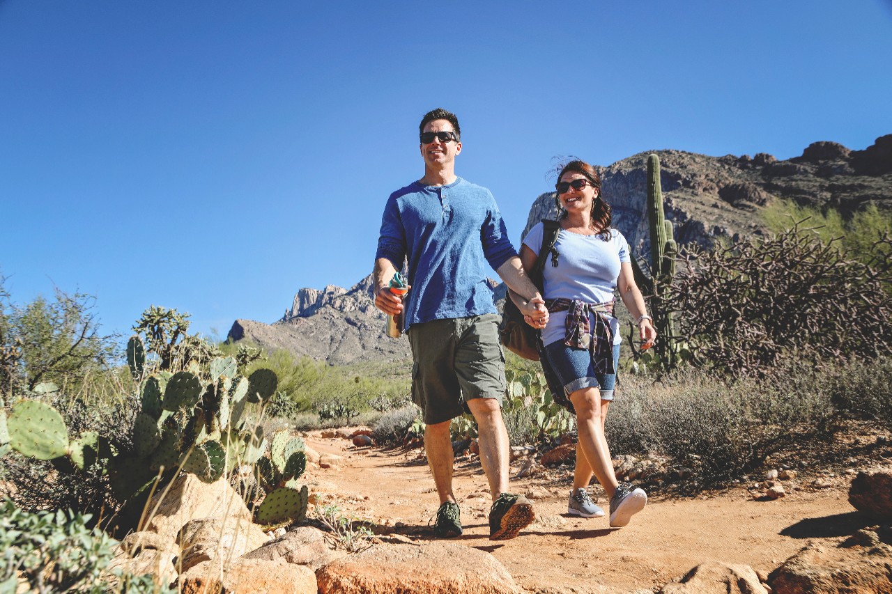 Couple hiking holding hands in desert