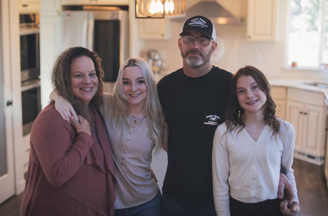 Family in their new kitchen after rebuilding following a wildfire