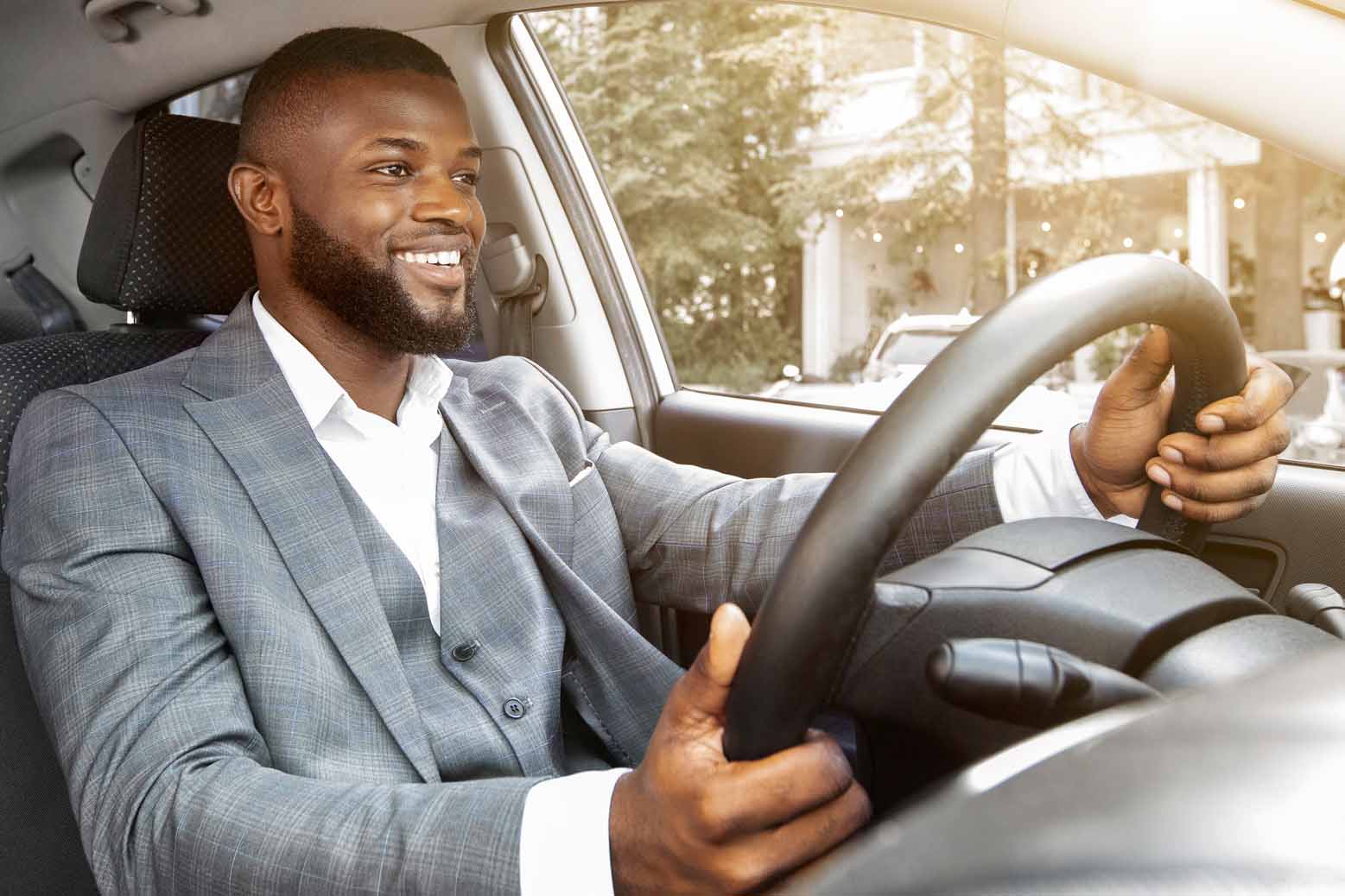Confident, happy young man driving a car.