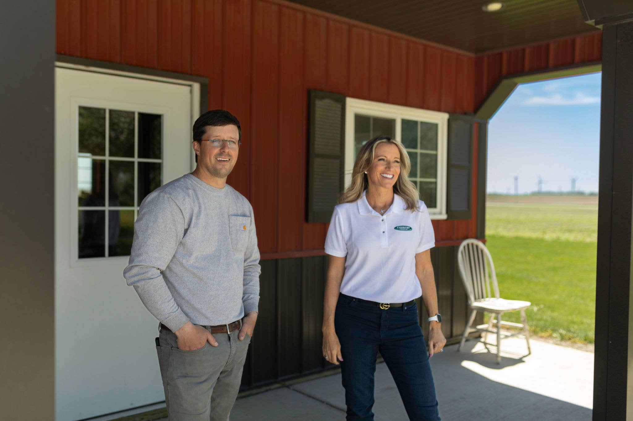 Insurance representative and customer standing outside a building.