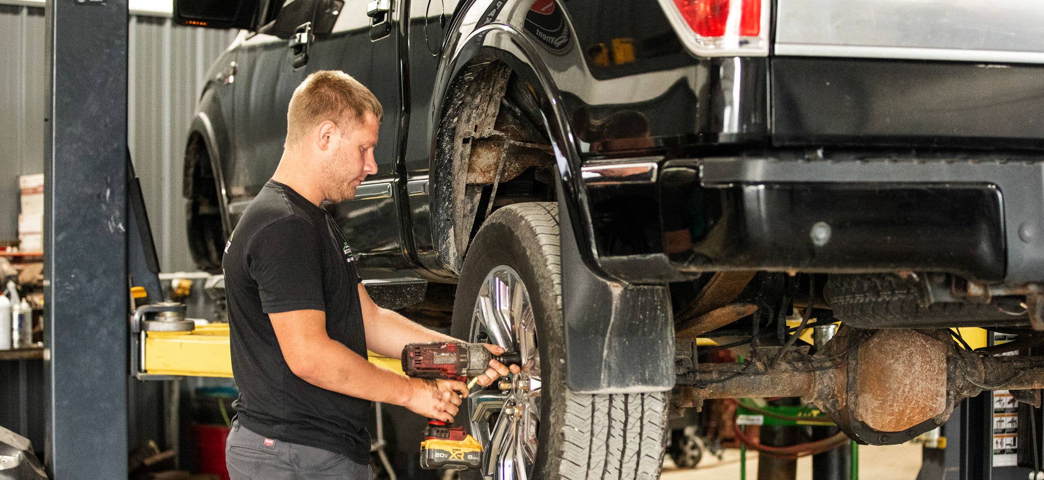 Mechanic screwing on wheels to a truck