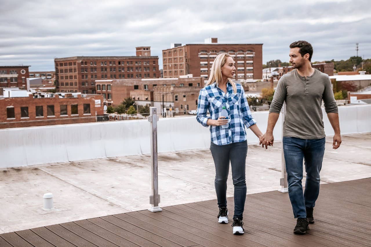 Couple holding hands walking on a rooftop