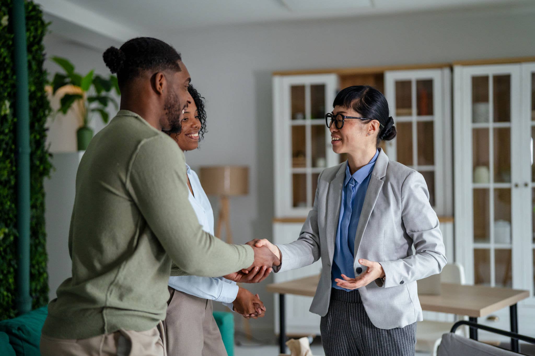 Real estate agent meeting a couple, shaking hands