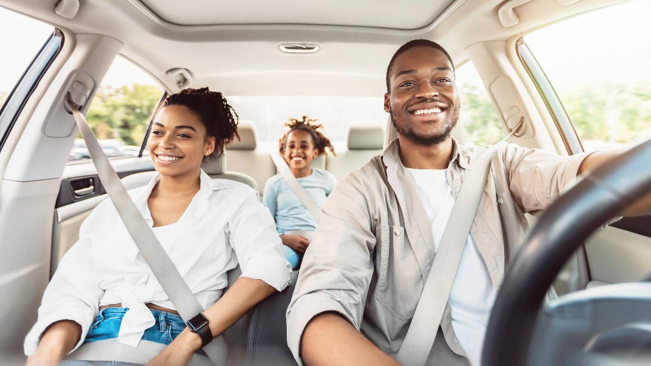 Happy African American Family Riding Car Traveling By Automobile. Black Parents And Daughter Enjoying Summer Road Trip Together On Weekend. Panorama, Selective Focus