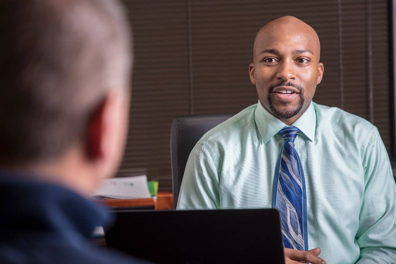 Two men talking across a desk