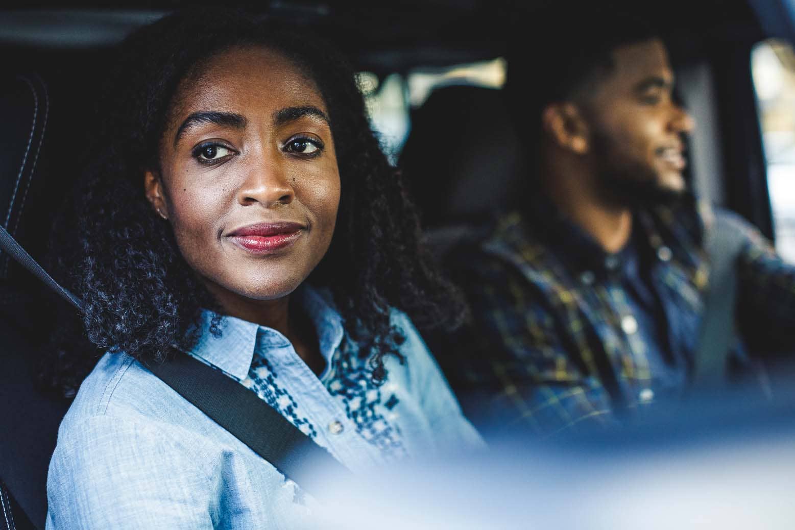 Man and woman in car, woman looking out the window.