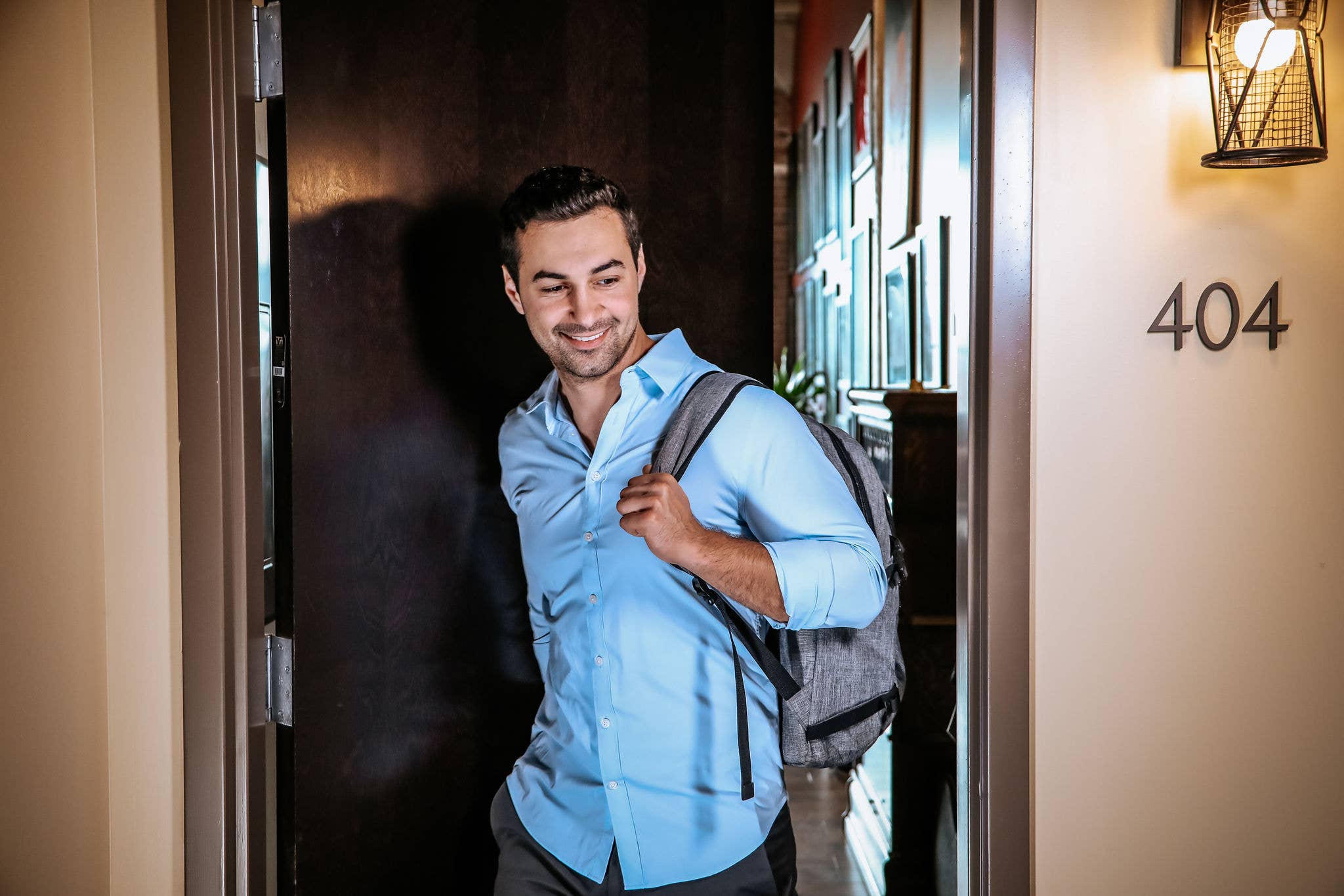 Man with backpack walking out of apartment
