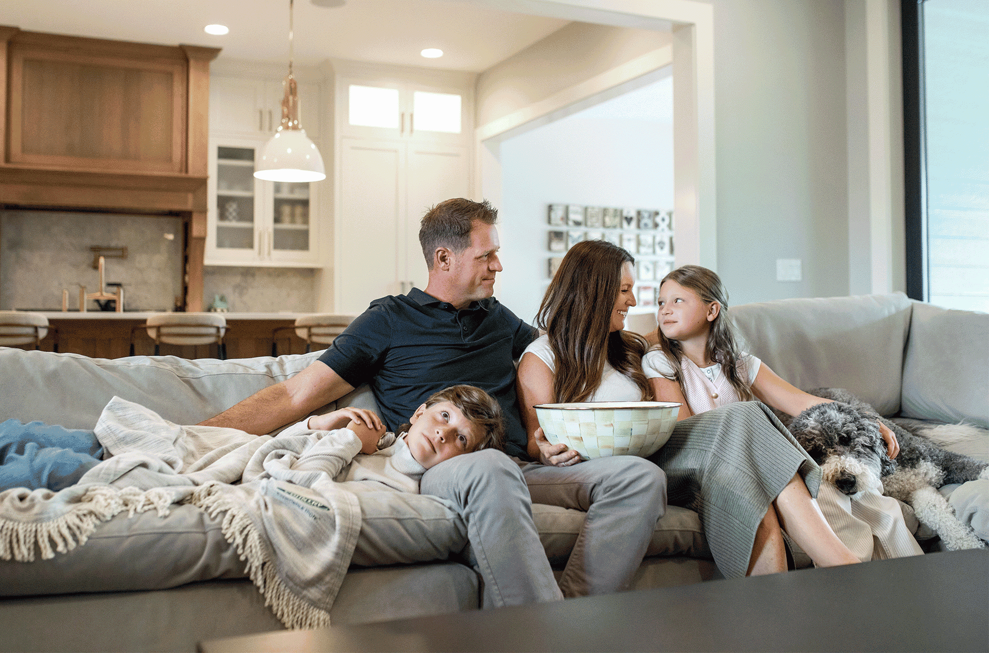 A family sitting on a couch in their home.