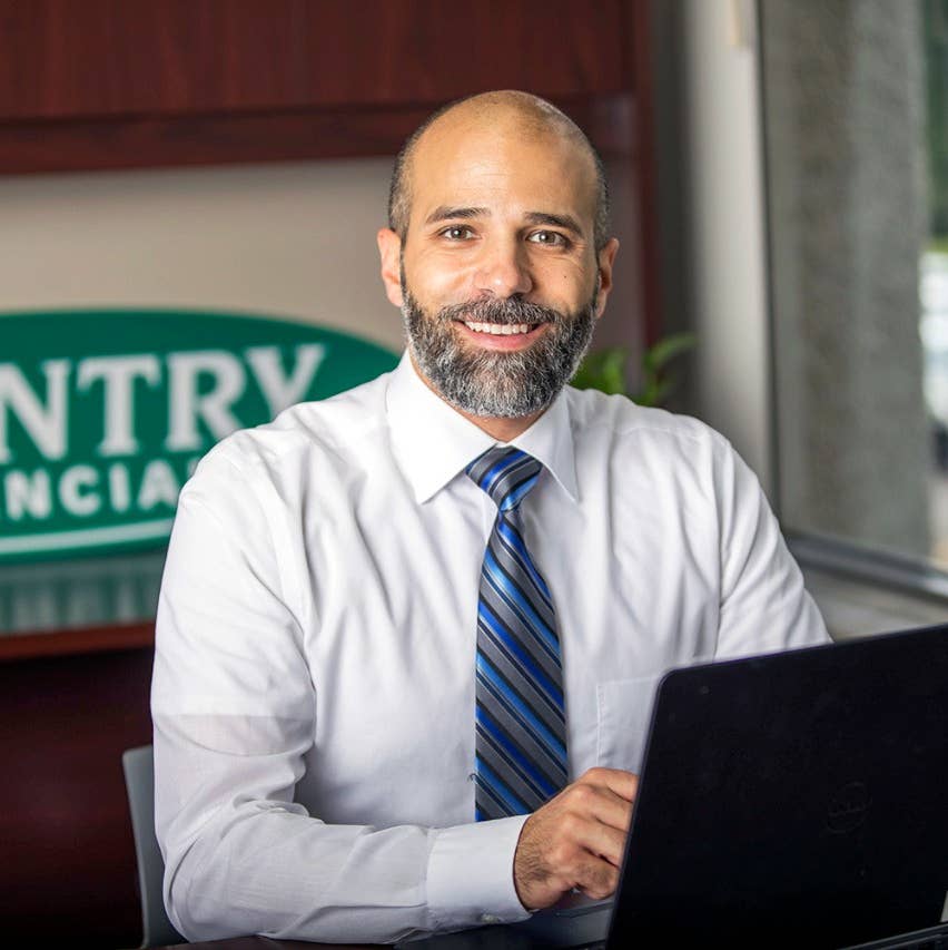 Smiling insurance agent at desk with laptop