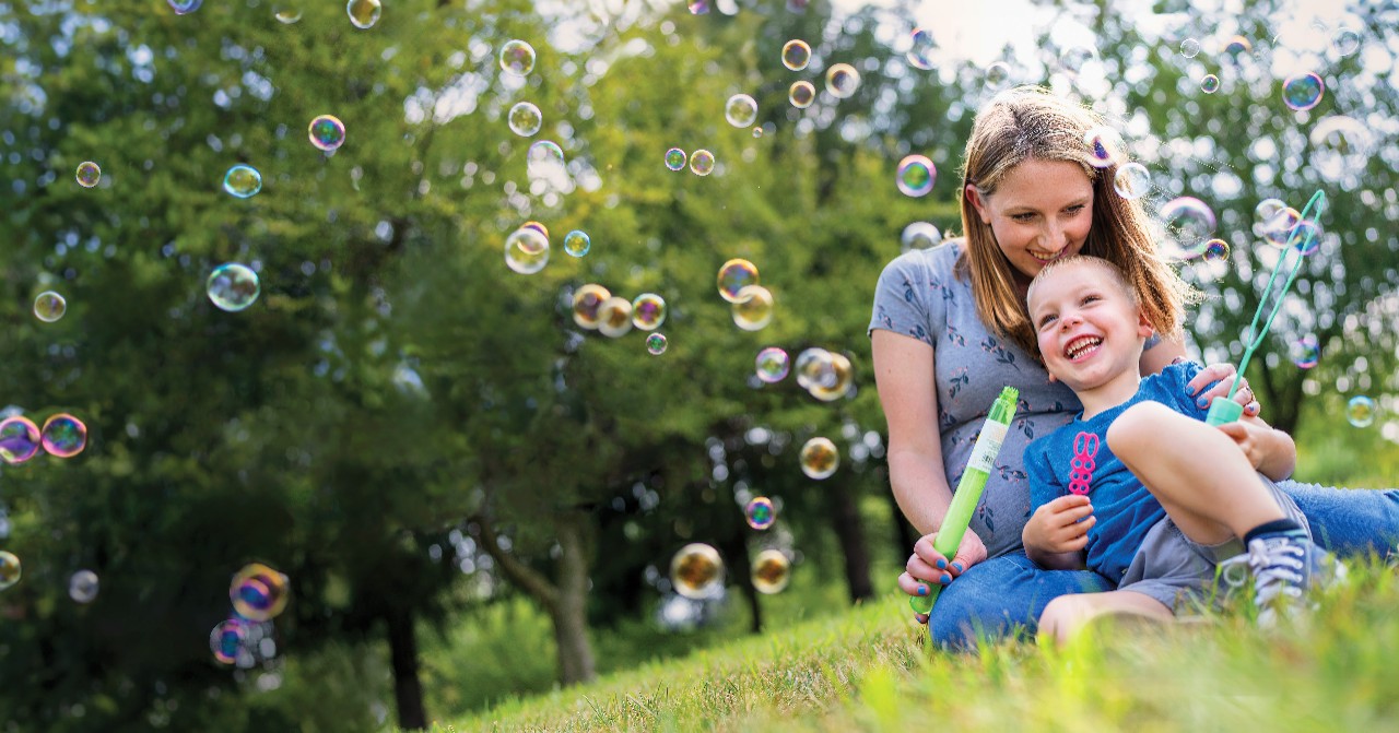 Mother and son in field blowing bubbles