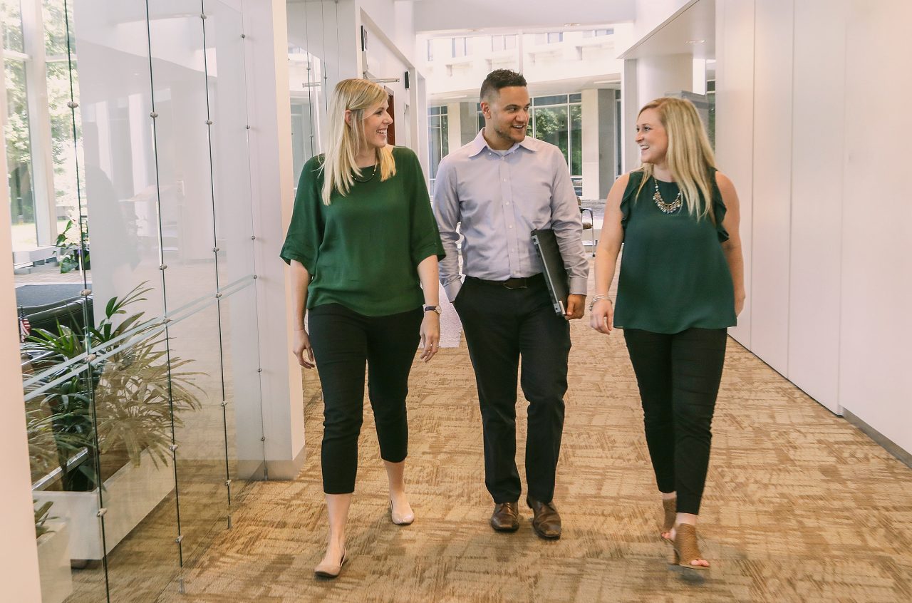 Three Country Financial employees walking in corporate office hallway
