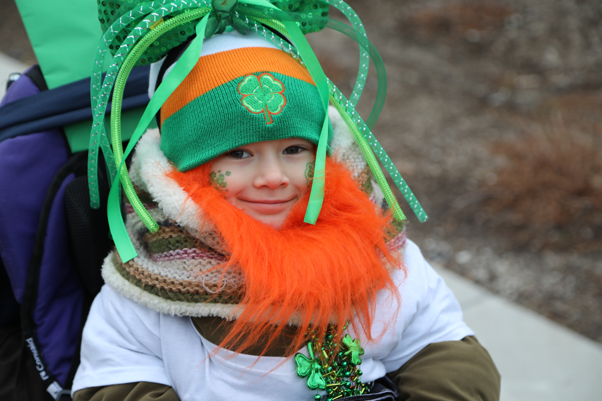 Child in stroller dressed for St. Patrick's Day