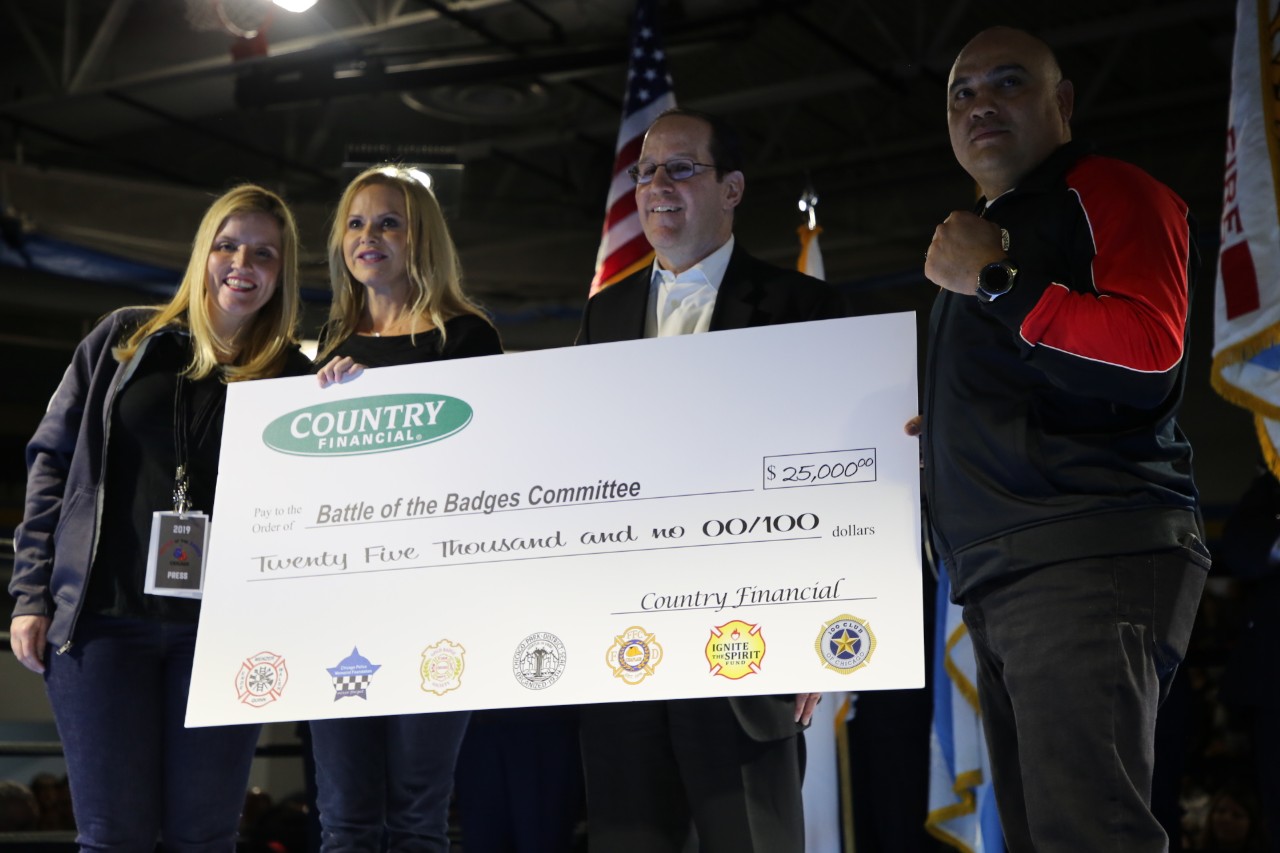 Country Financial awards Battle of the Badges Committee with check