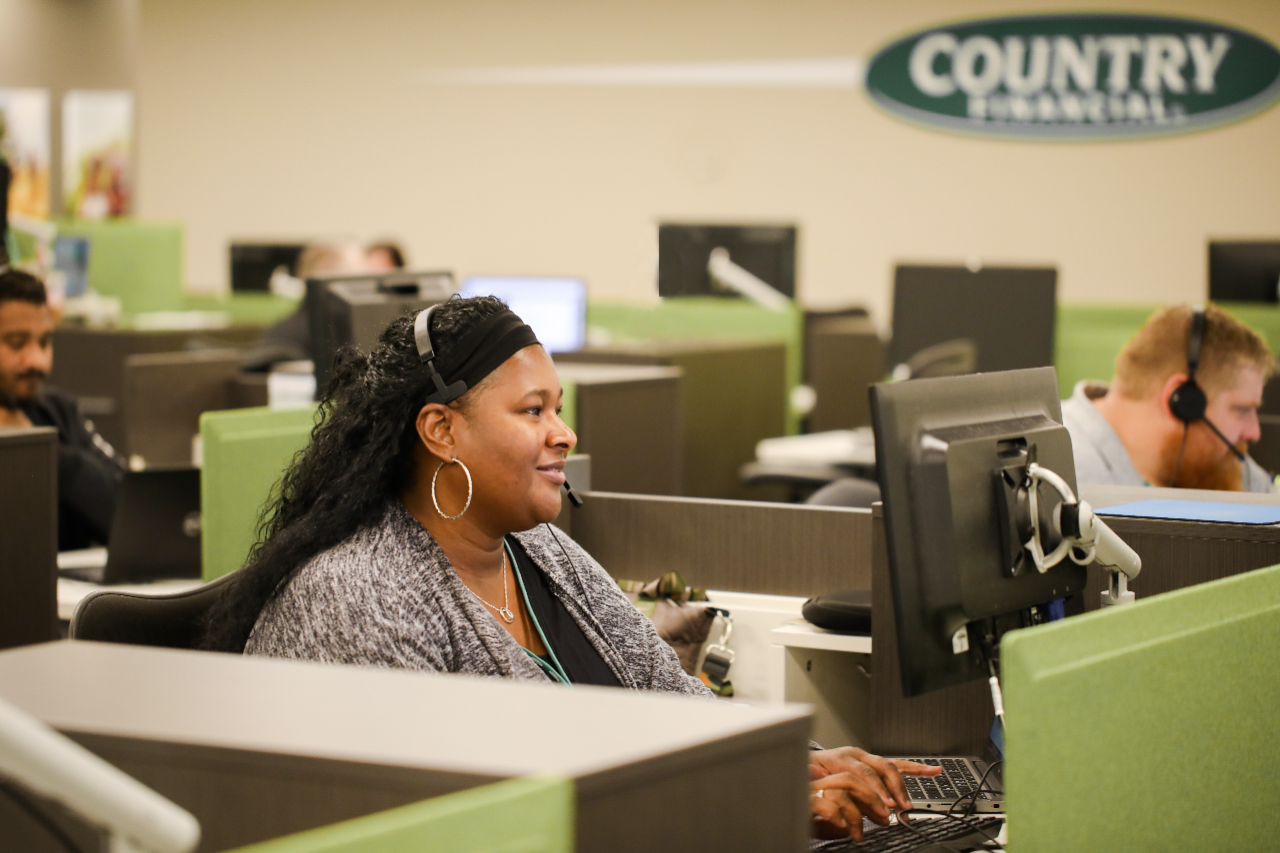 Employee at desk with CF logo in background