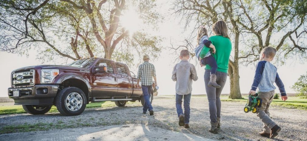 Family walking to red truck in driveway