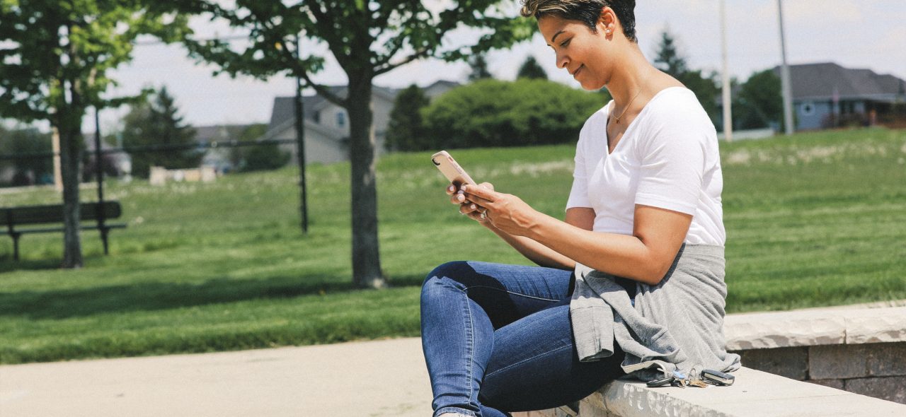 Mom sitting at park on smart phone