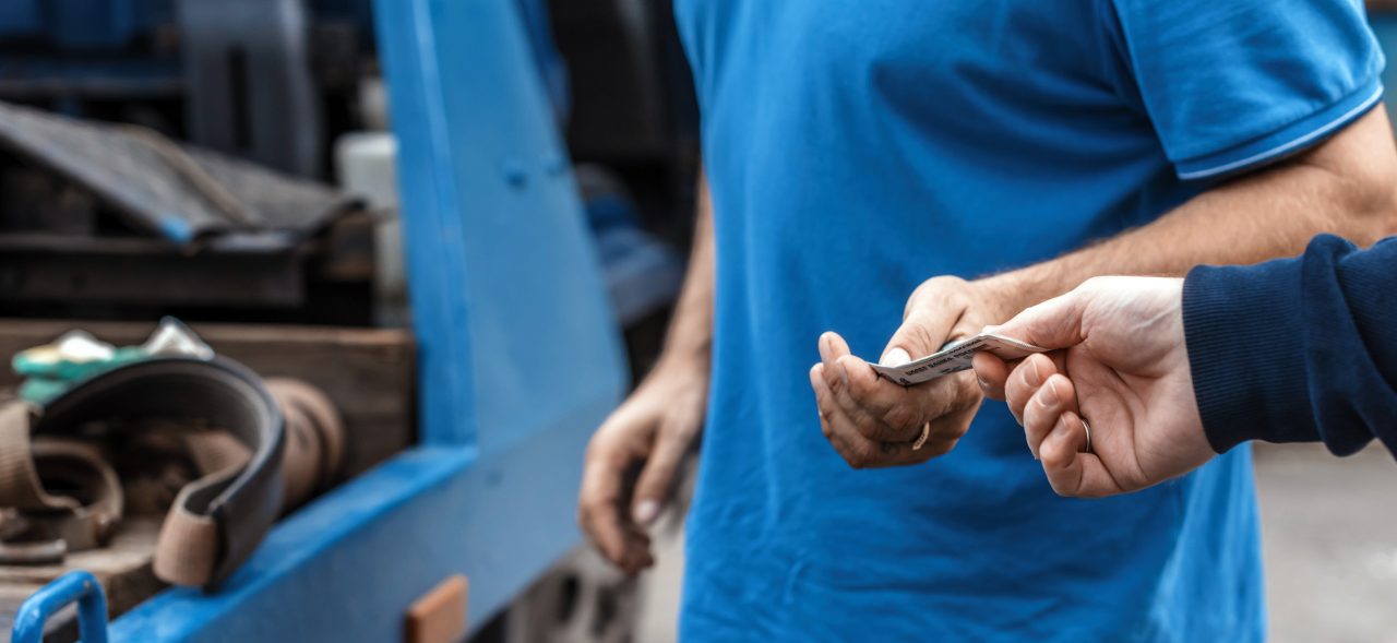 Man pays paper money for tow truck to worker towing a broken down car. Selective focus. Concept 