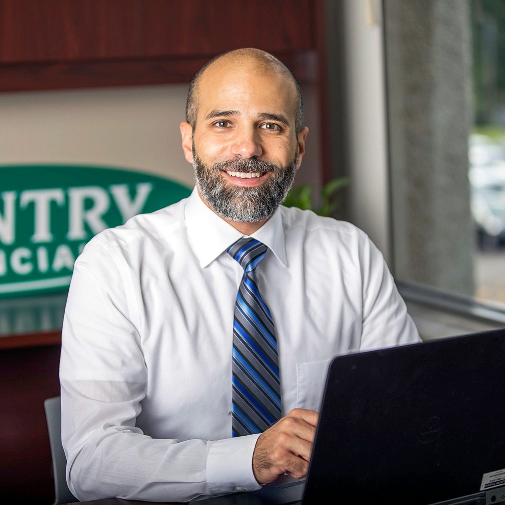 Smiling insurance agent at desk with laptop