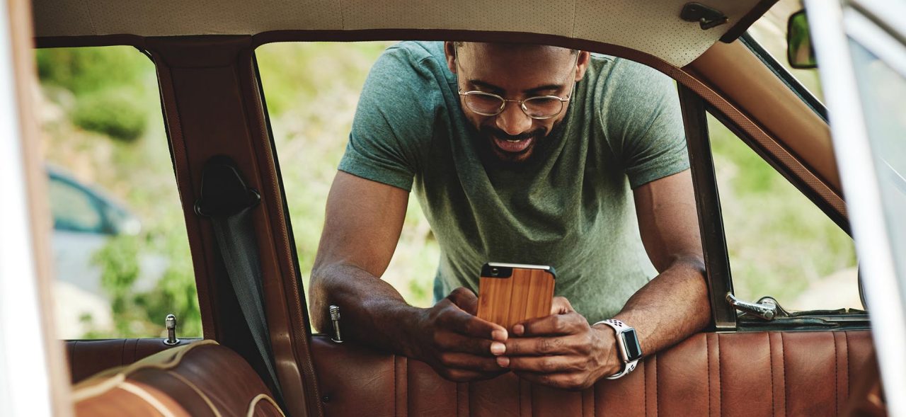 Shot of a young man using a smartphone during a road trip
