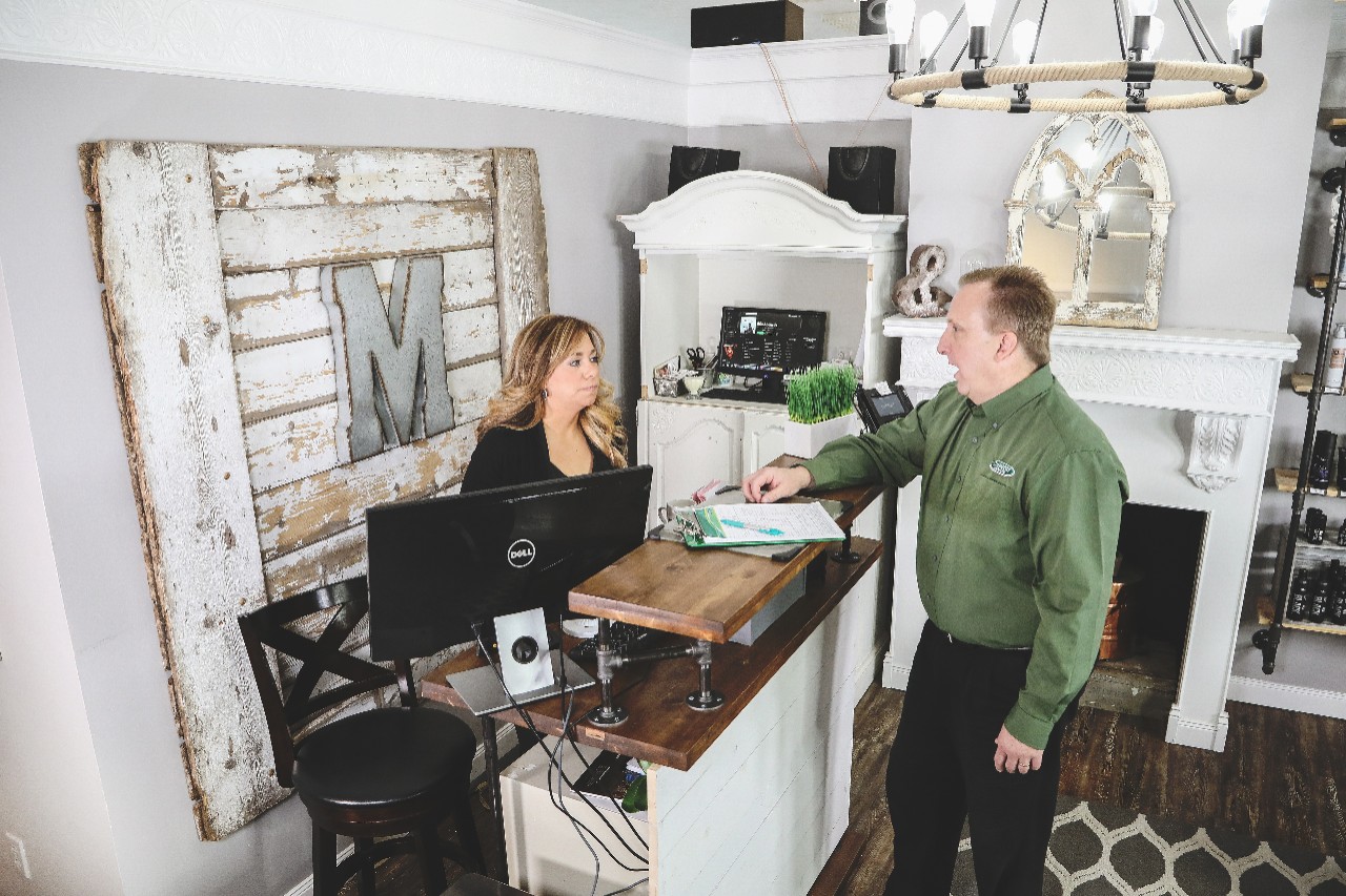 Insurance representative and business owner talking at salon counter