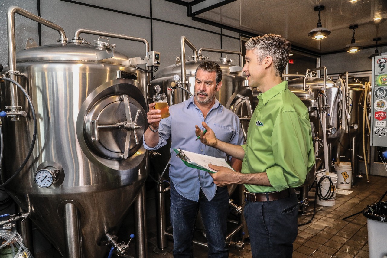 A COUNTRY Financial representative and a business owner inside a brewery