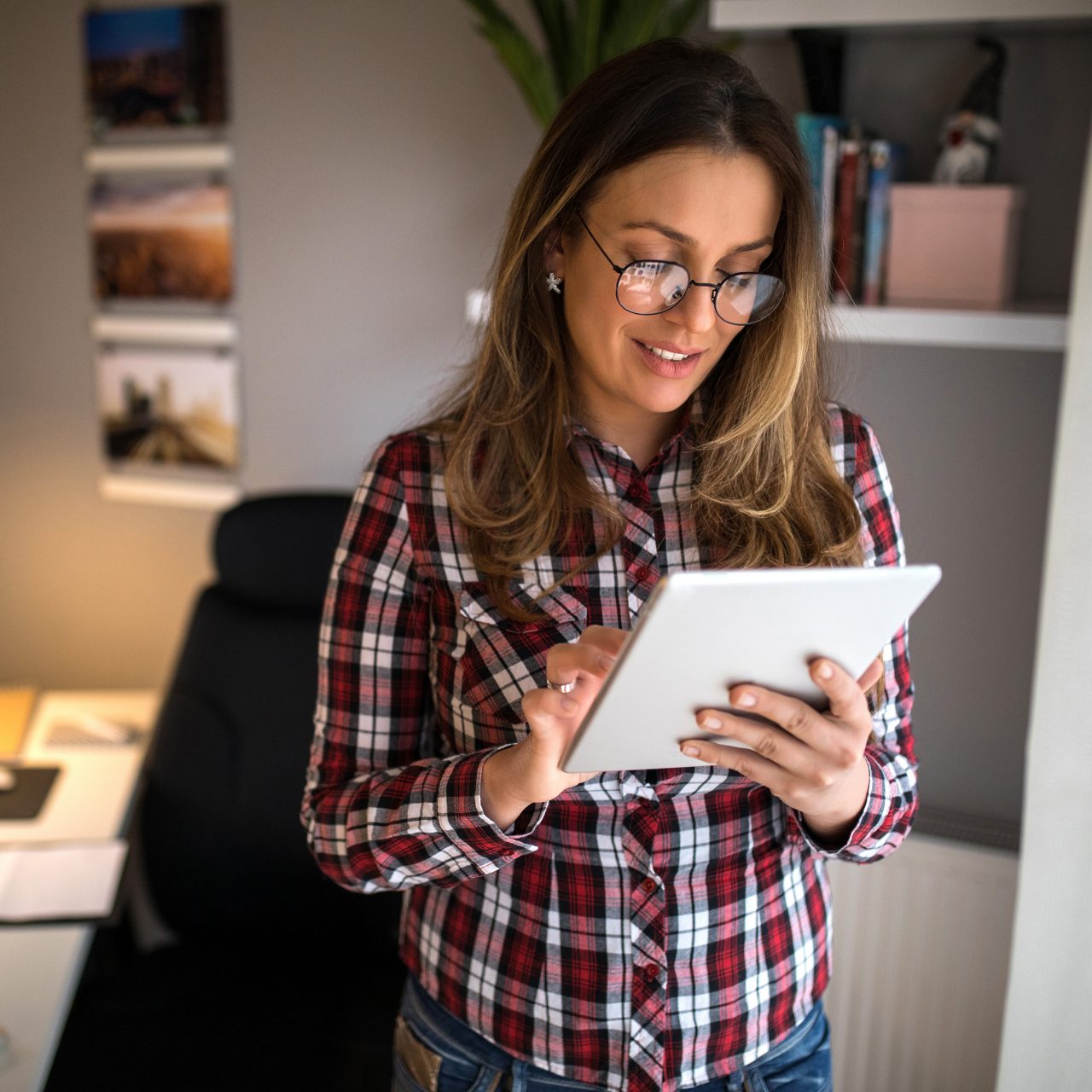 Woman in home office standing on tablet