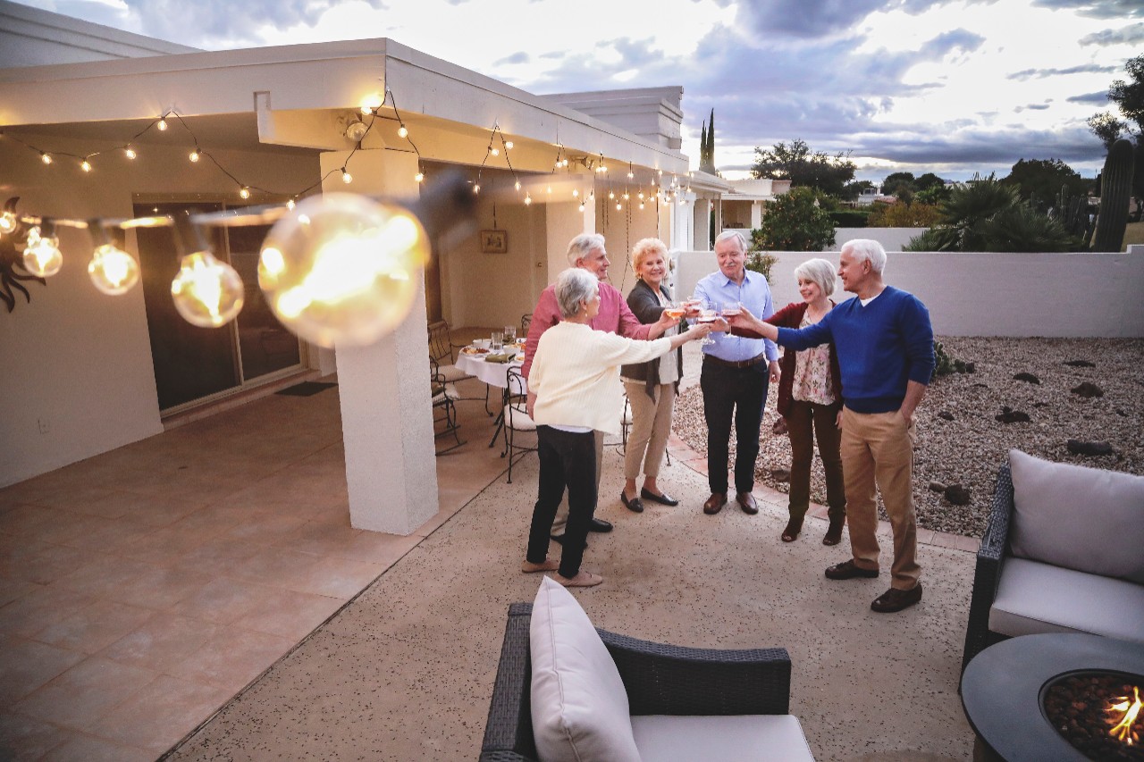 Seniors cheers in celebration on back patio of house