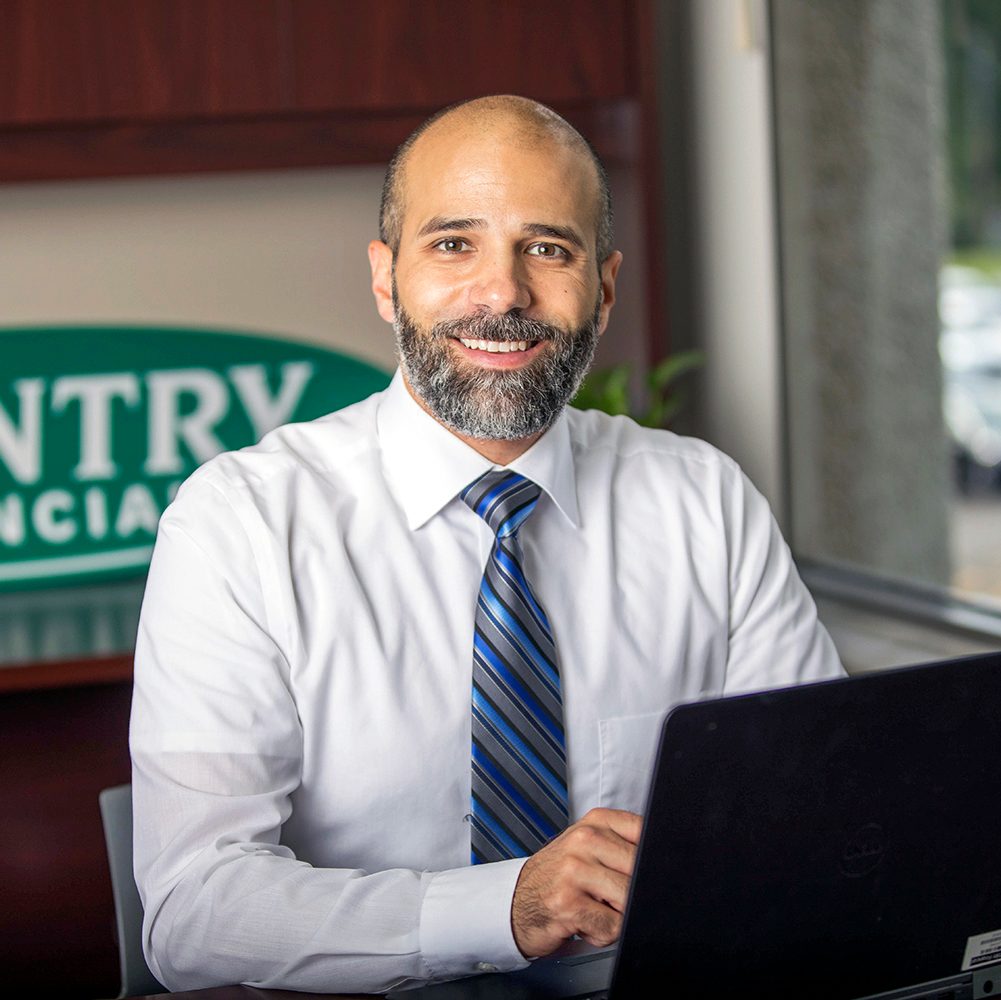 Smiling insurance agent at desk with laptop