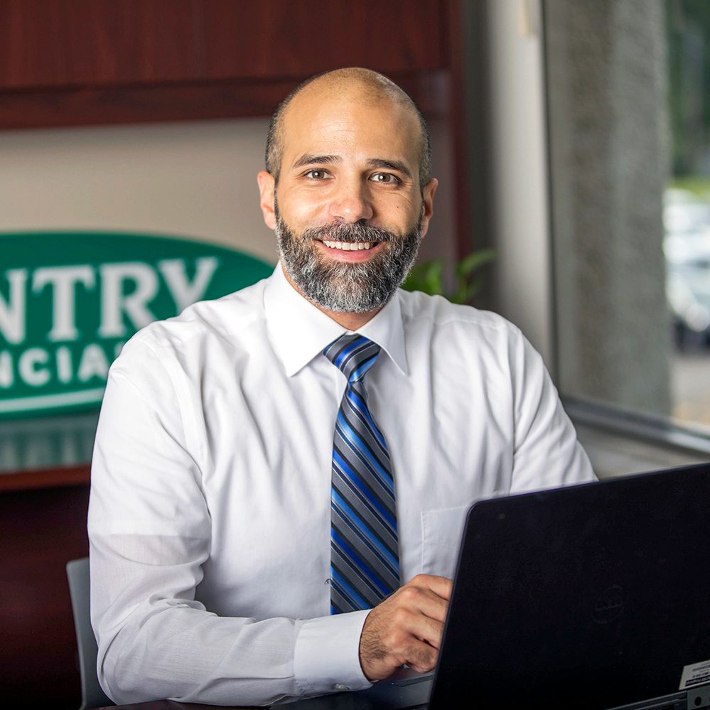 Smiling insurance agent at desk with laptop