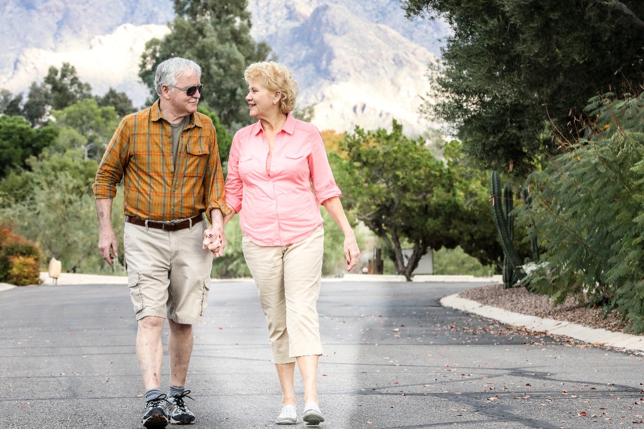 Senior couple holding hands walking on the road
