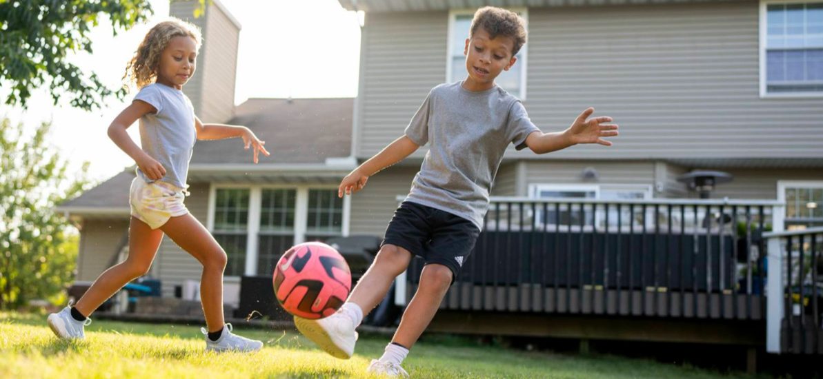 kids playing soccer in backyard