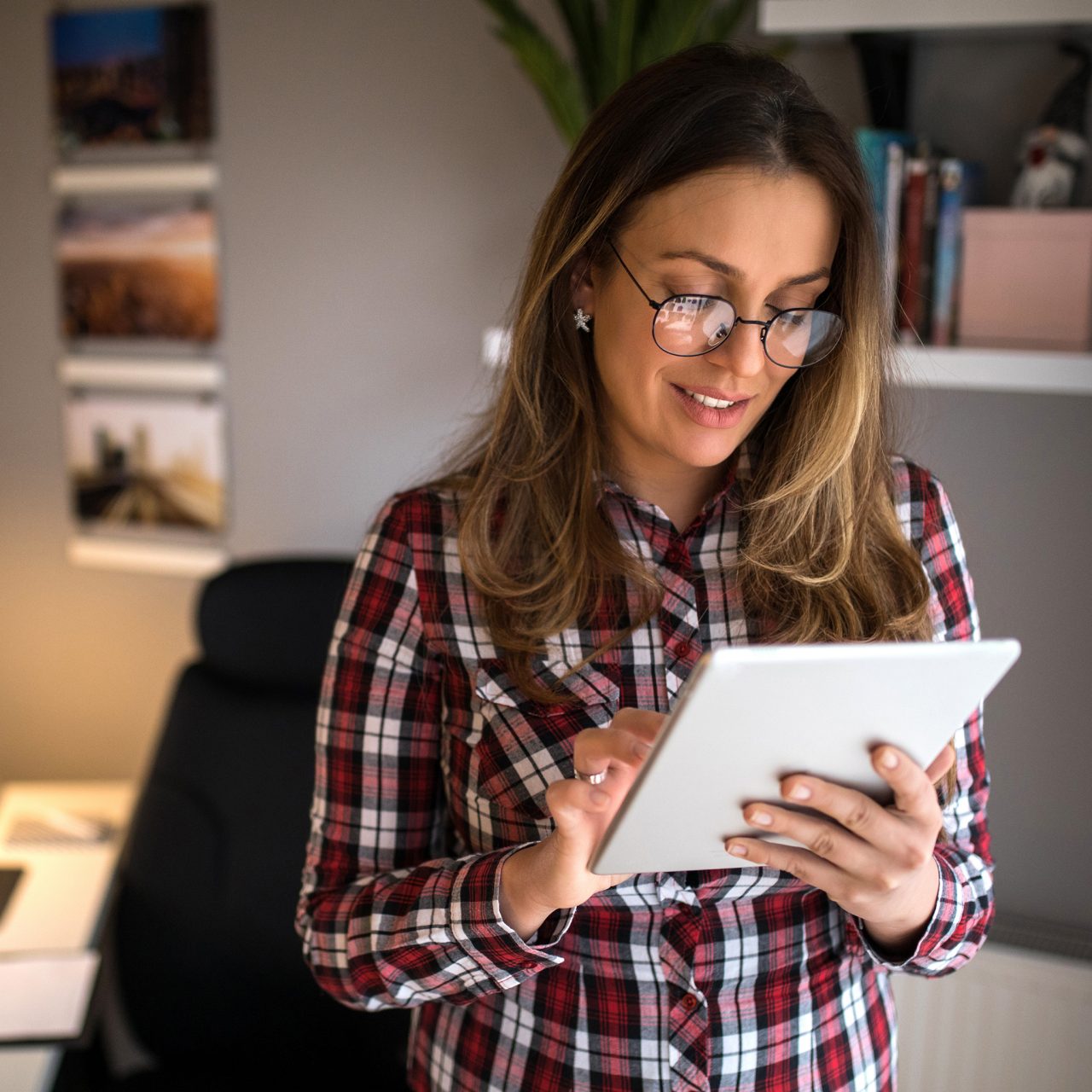 Woman in home office standing on tablet