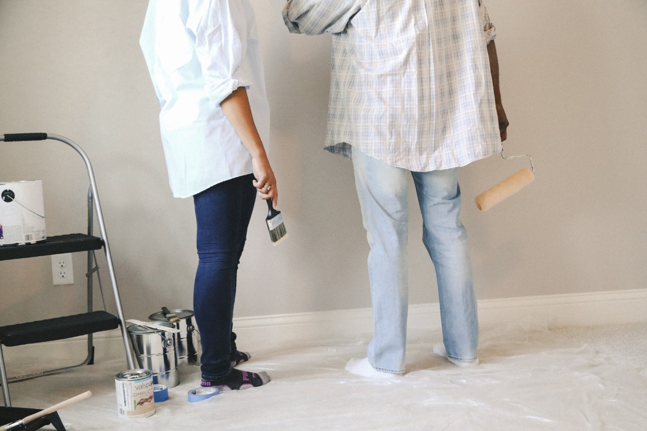 Two homeowners painting a wall