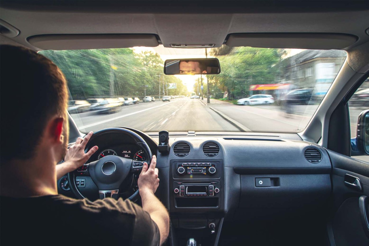 Man driving car, view from back seat.