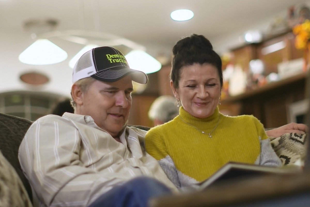 Couple sitting on couch reading book