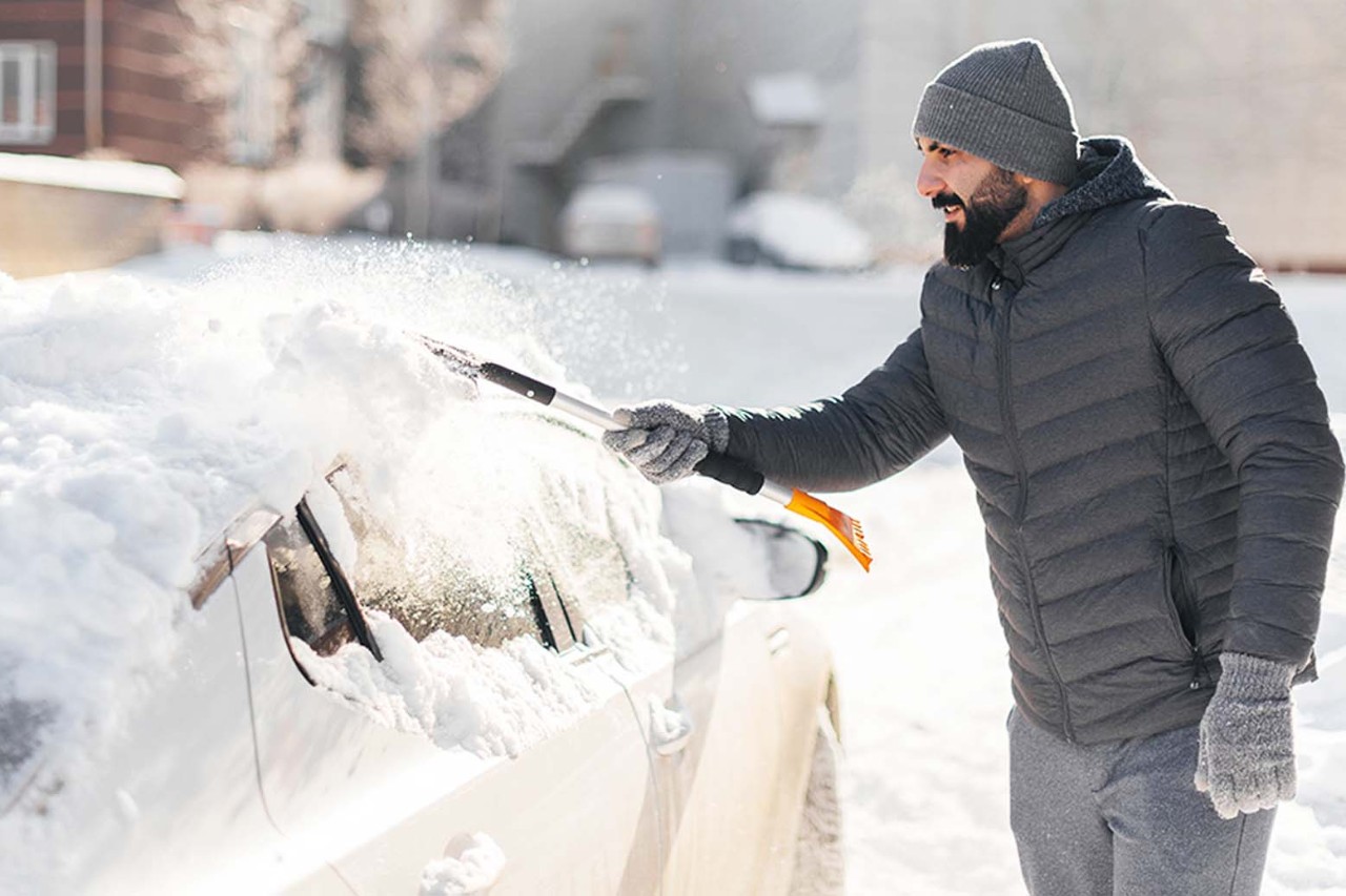 Man removing snow from car
