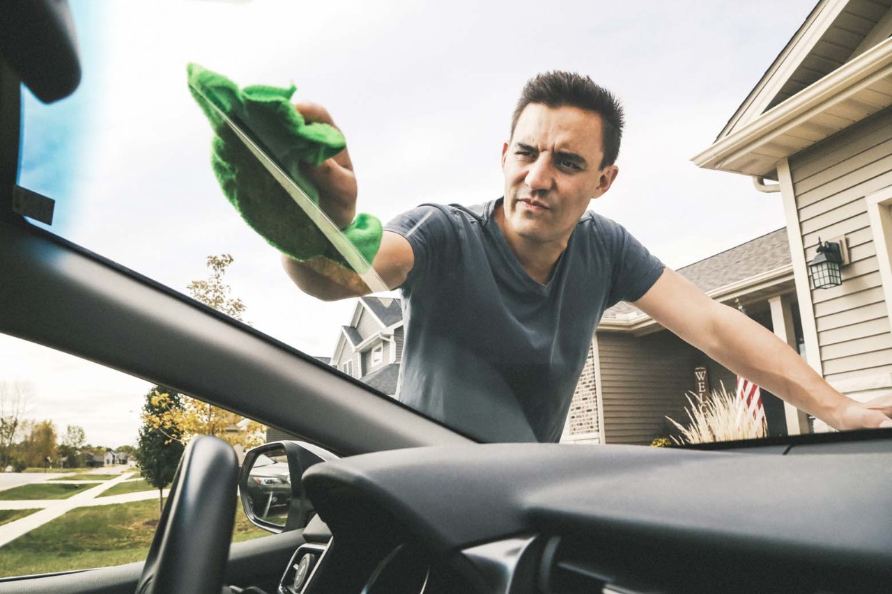 Man washing the windshield of his car
