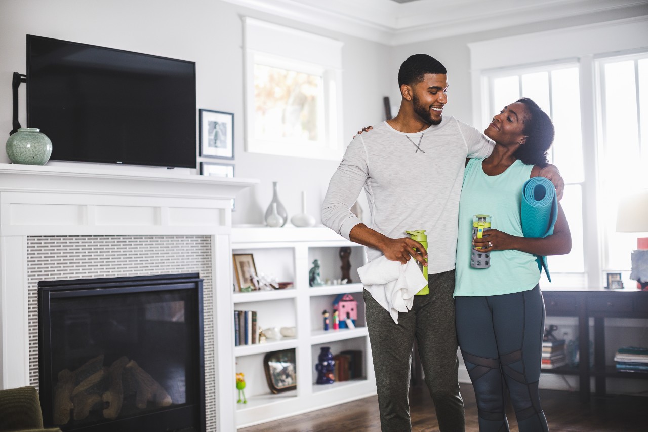 Couple embrace in living room.