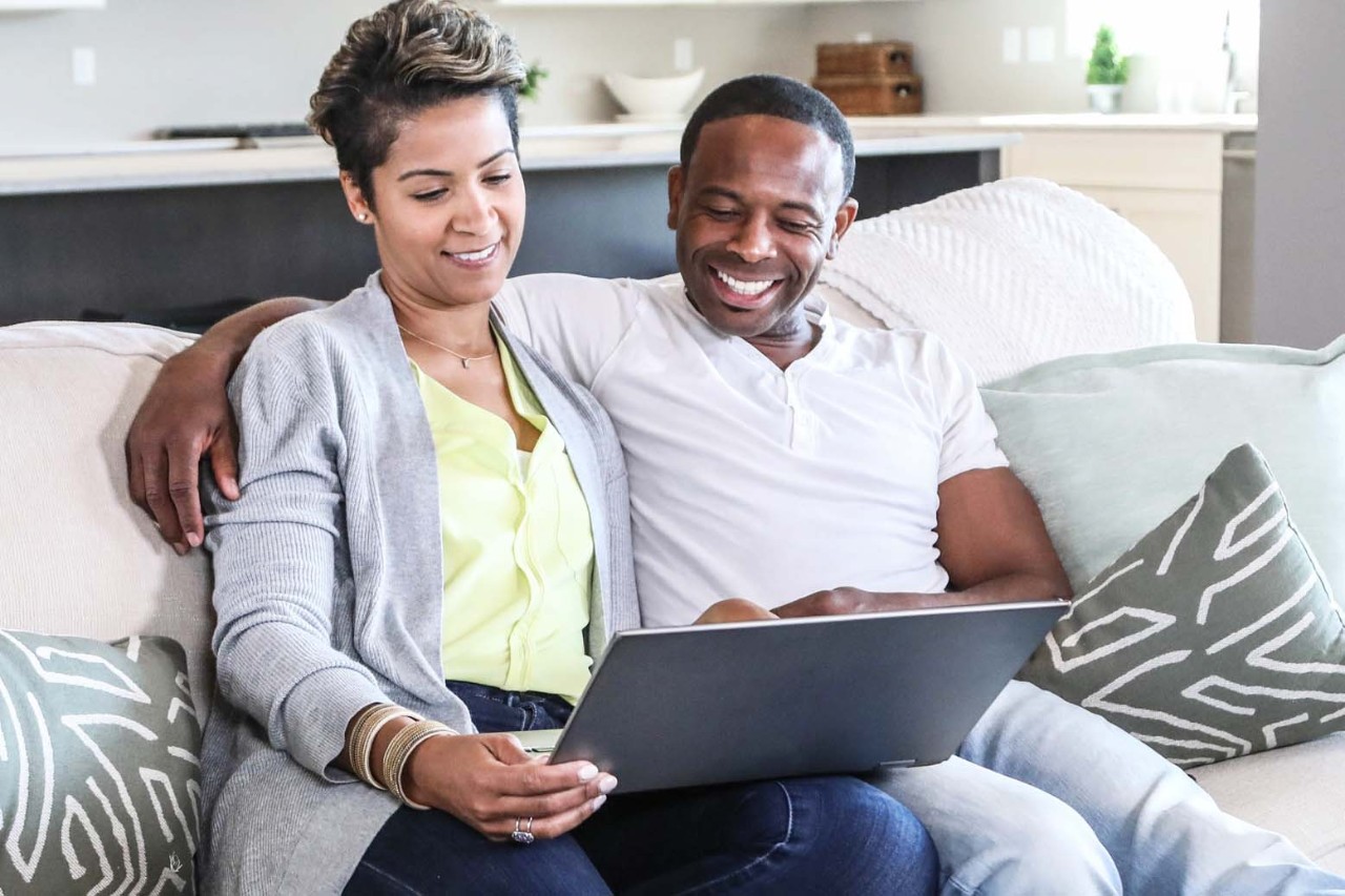 Couple sitting on a couch with laptop