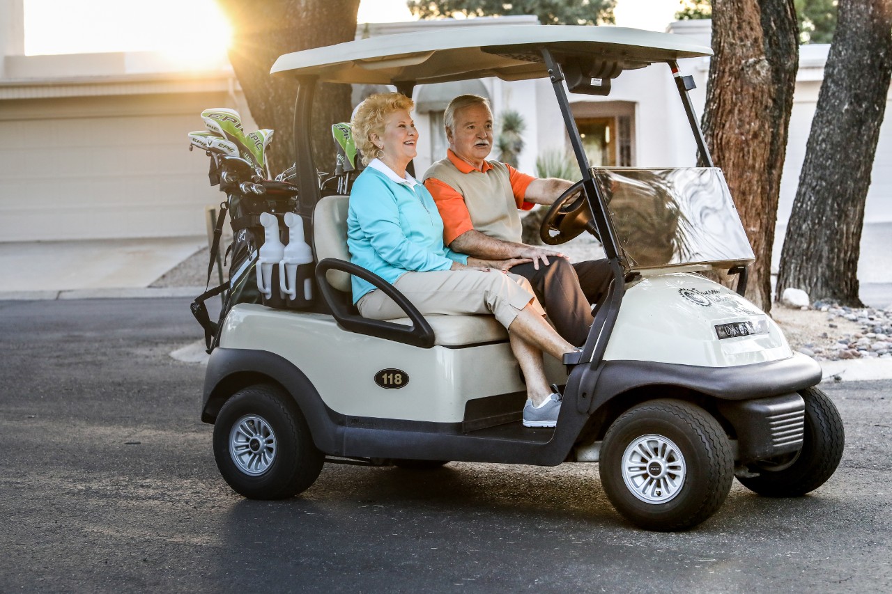Senior couple driving a golf cart