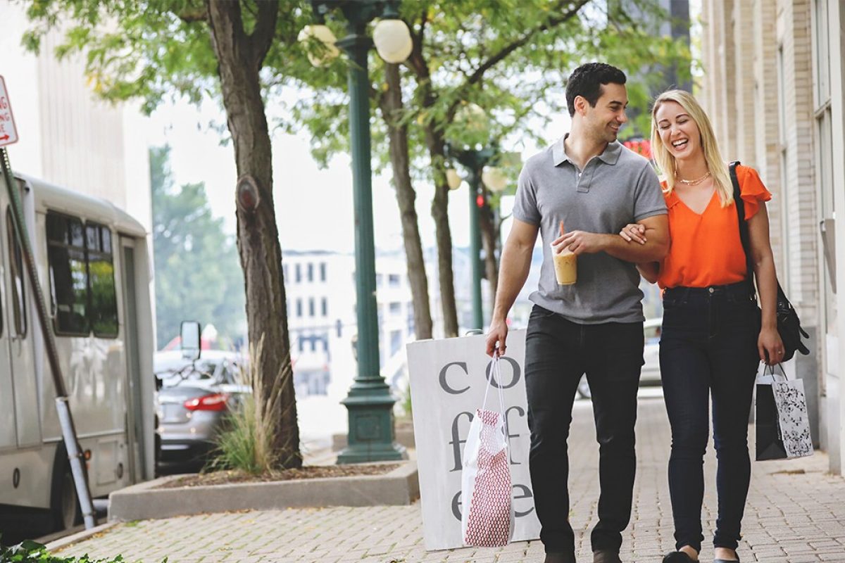 Couple with shopping bags and coffee walking in town