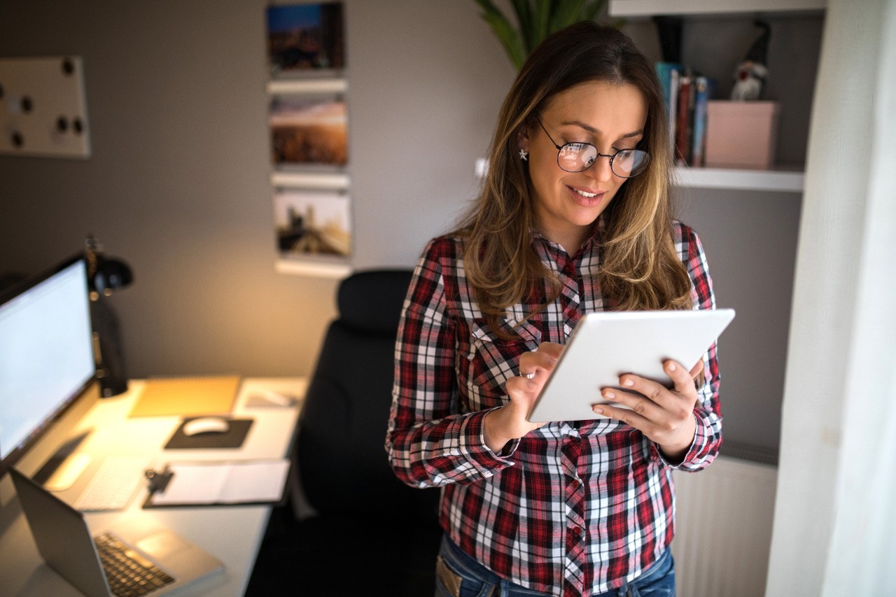 Woman in home office standing on tablet