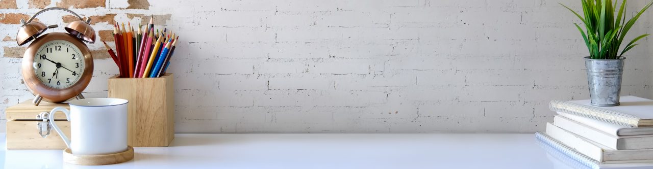 Modern white top of desk against white brick wall